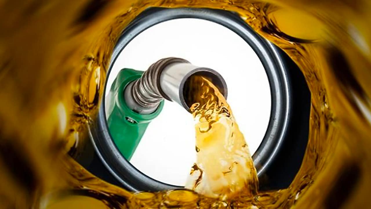 Vue depuis l'intérieur d'un réservoir de carburant Shell Fuelsave pendant le remplissage, avec pompe verte versant de l'essence dorée