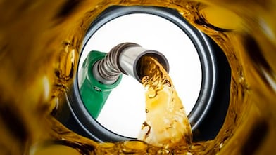 Vue depuis l'intérieur d'un réservoir de carburant Shell Fuelsave pendant le remplissage, avec pompe verte versant de l'essence dorée