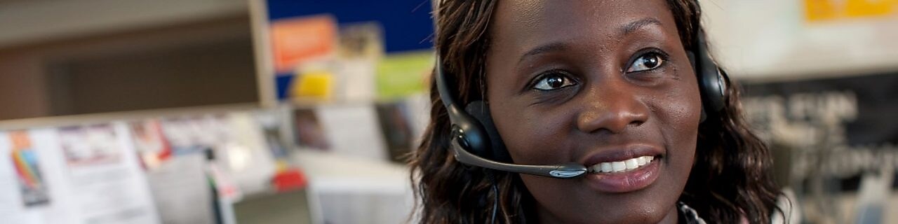 Collaboratrice souriante au téléphone avec un client