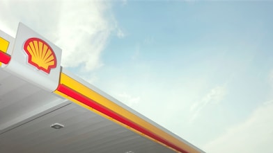 Logo Shell sur l'auvent d'une station-service contre un ciel bleu clair