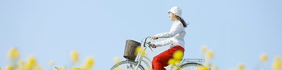 Une jeune femme fait une balade à vélo dans un champ en fleurs en été