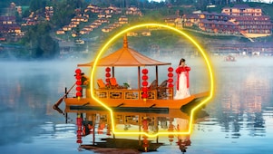 Bateau traditionnel chinois décoré de lanternes rouges sur un lac brumeux, avec un grand cercle lumineux entourant la scène