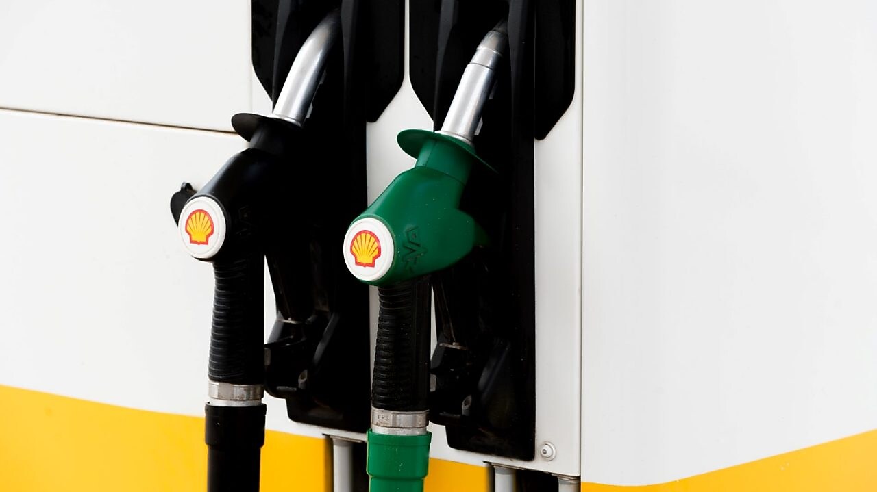Pompes à essence noires et vertes d'une station Shell montrant deux types de carburant différents