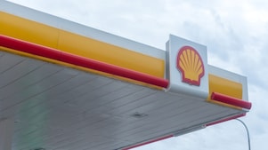 Logo Shell sur la façade d'une station-service avec bandes décoratives rouges et jaunes