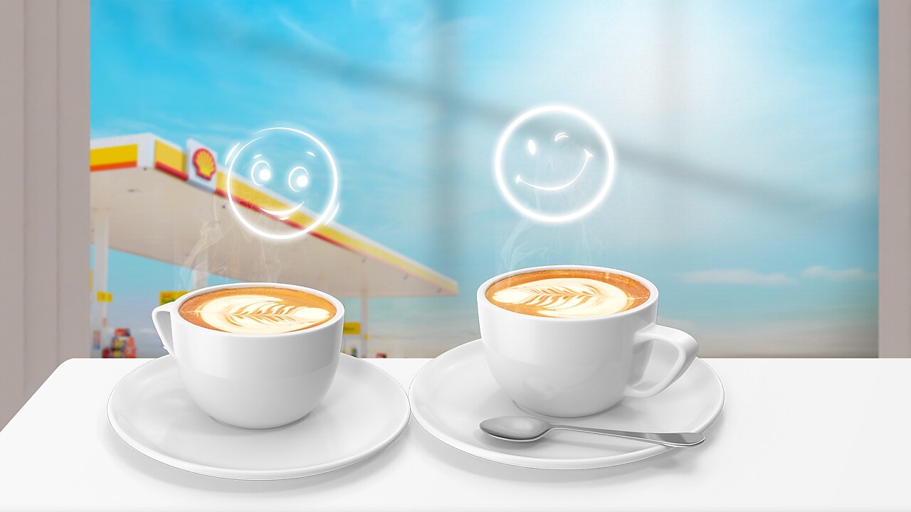 Deux tasses de café latte avec motifs de feuilles dessinés dans la mousse de lait, surmontées d'émojis souriants lumineux