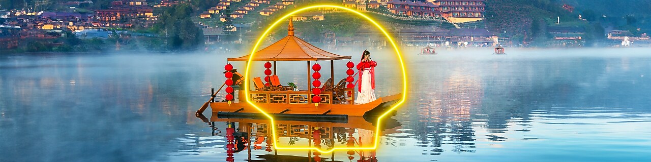 Une Chinoise vêtue d’une robe blanche rouge se tient debout sur un bateau.