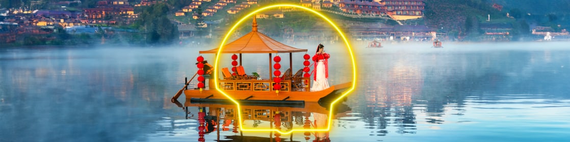 Une Chinoise vêtue d’une robe blanche rouge se tient debout sur un bateau.