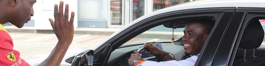 Deux personnes se saluant devant une boutique  Shell Select, l'une dans une voiture et l'autre debout à l'extérieur.