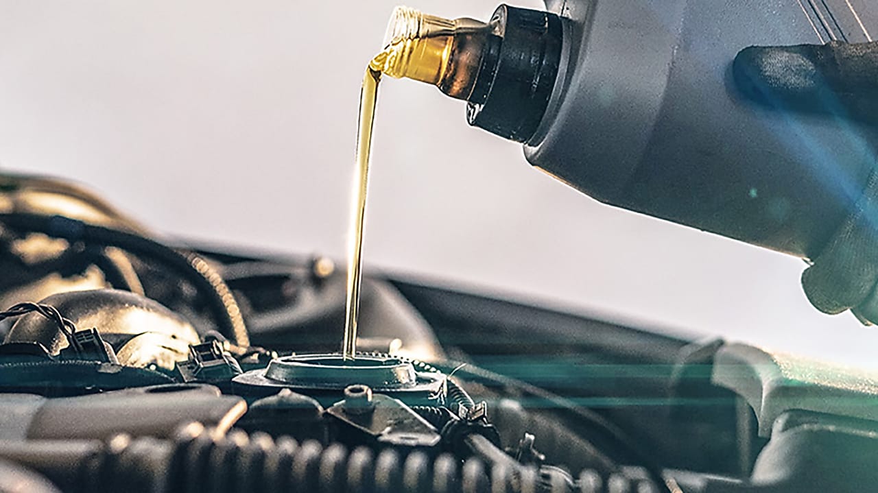 Lubrifiant Shell doré versé dans le compartiment moteur d'une voiture lors d'une vidange