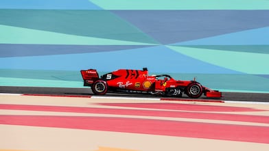 Voiture Ferrari de Formule 1 rouge sur circuit avec bandes colorées, lors d'une course à Bahreïn