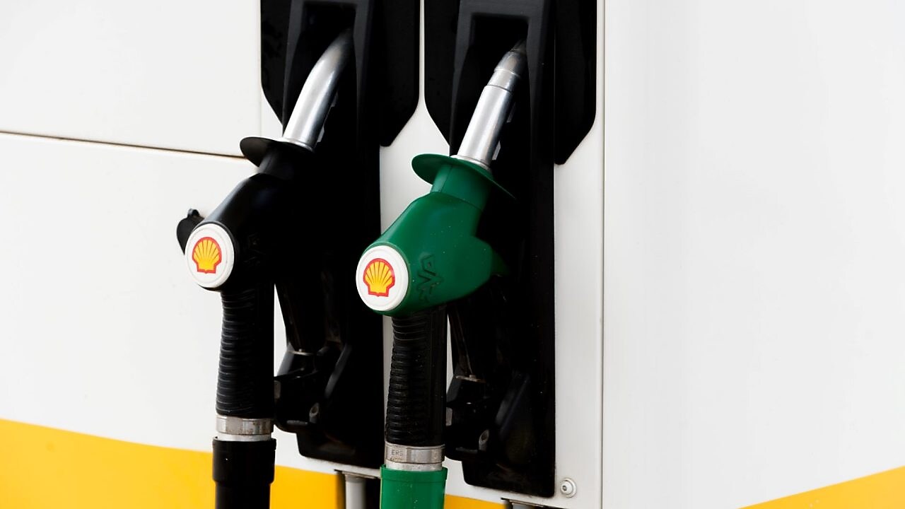 Pompes à essence noires et vertes d'une station Shell montrant deux types de carburant différents