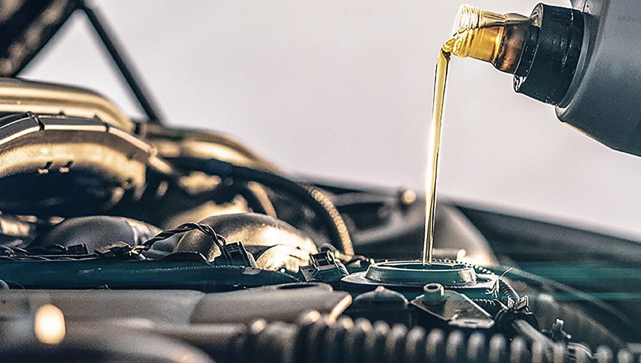 Huile de moteur dorée versée dans le compartiment moteur d'une voiture lors d'une vidange