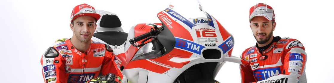 Deux pilotes de course en combinaison rouge Ducati posant avec leur moto de MotoGP aux couleurs de l'équipe TIM