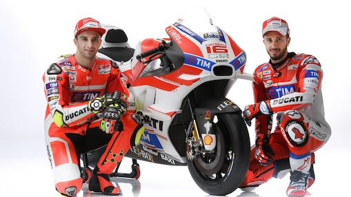 Deux pilotes de course en combinaison rouge Ducati posant avec leur moto de MotoGP aux couleurs de l'équipe TIM