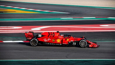 Voiture Ferrari F1 numéro 16 en action sur un circuit de course avec bordures rouge et vert