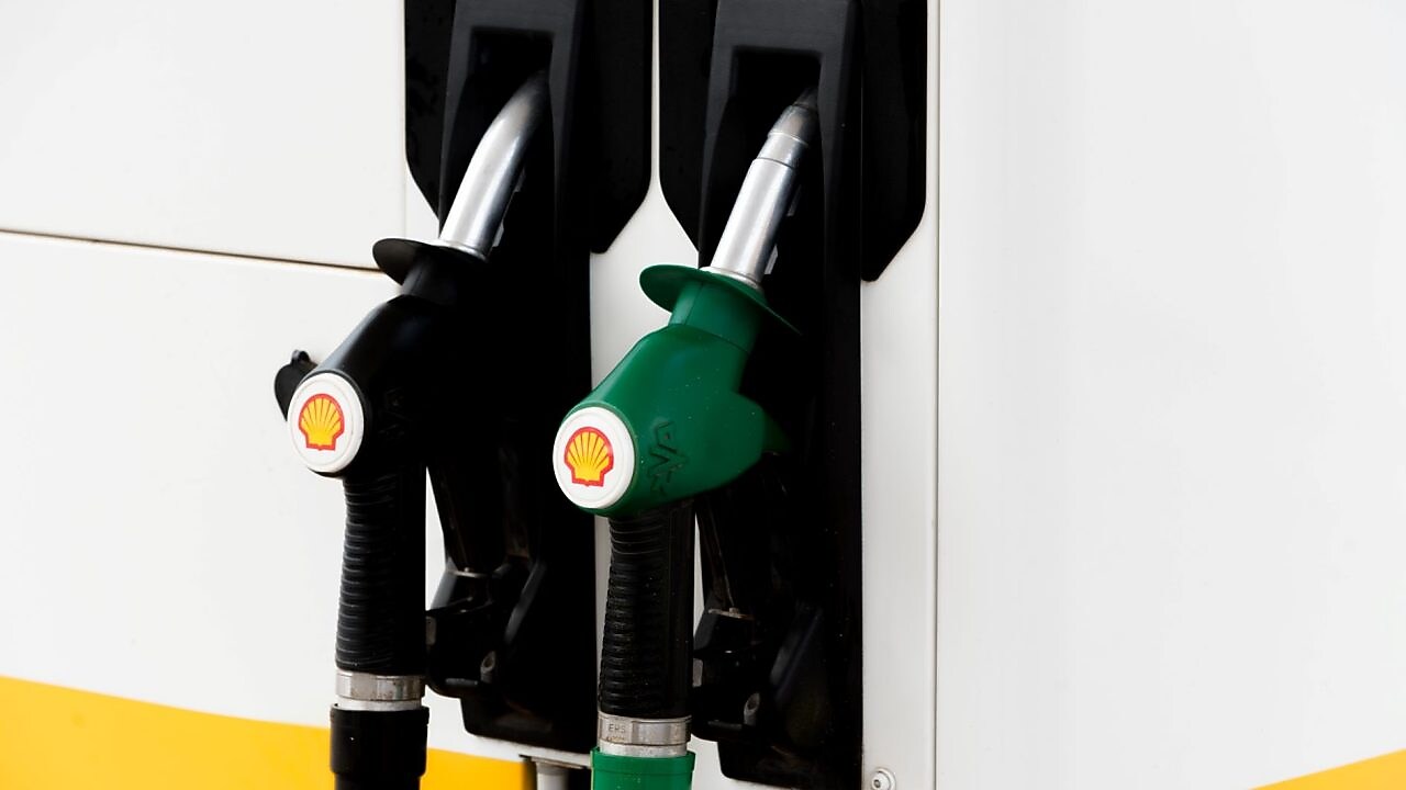 Pompes à essence noires et vertes d'une station Shell montrant deux types de carburant différents