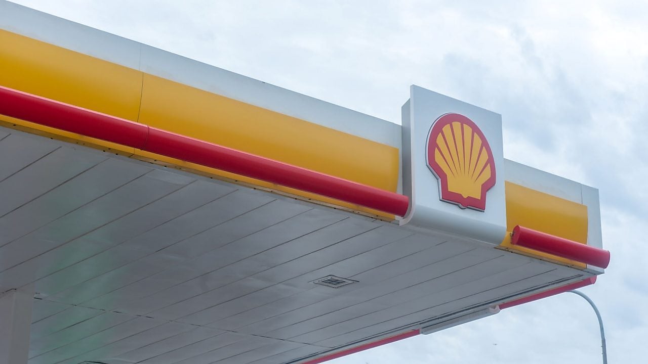 Logo Shell sur la façade d'une station-service avec bandes décoratives rouges et jaunes