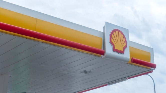 Logo Shell sur la façade d'une station-service avec bandes décoratives rouges et jaunes