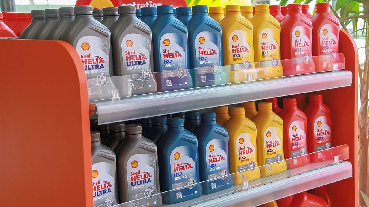 Bidons d'huiles moteur de la gamme Shell Helix alignés sur des étagères.