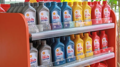 Bidons d'huiles moteur de la gamme Shell Helix alignés sur des étagères.