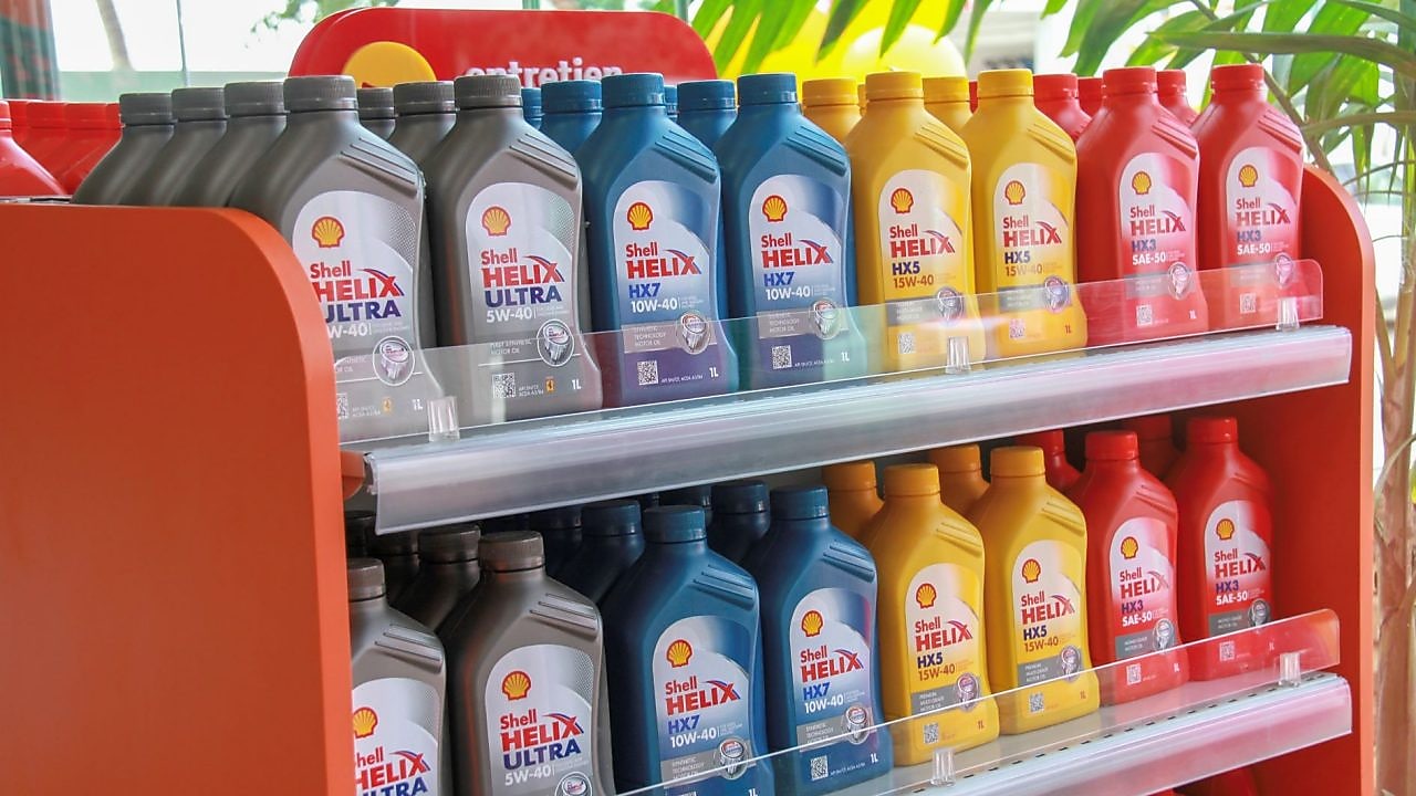 Bidons d'huiles moteur de la gamme Shell Helix alignés sur des étagères.