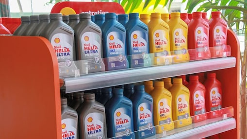 Bidons d'huiles moteur de la gamme Shell Helix alignés sur des étagères.