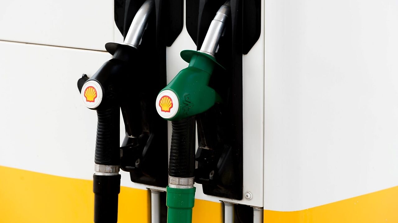 Pompes à essence noires et vertes d'une station Shell montrant deux types de carburant différents