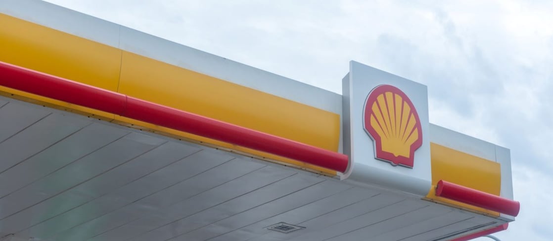Logo Shell sur la façade d'une station-service avec bandes décoratives rouges et jaunes