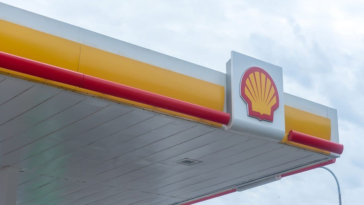 Logo Shell sur la façade d'une station-service avec bandes décoratives rouges et jaunes